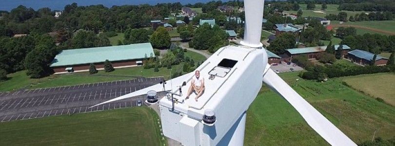 Un piloto de drones capta a un hombre tomando el sol en un molino eólico